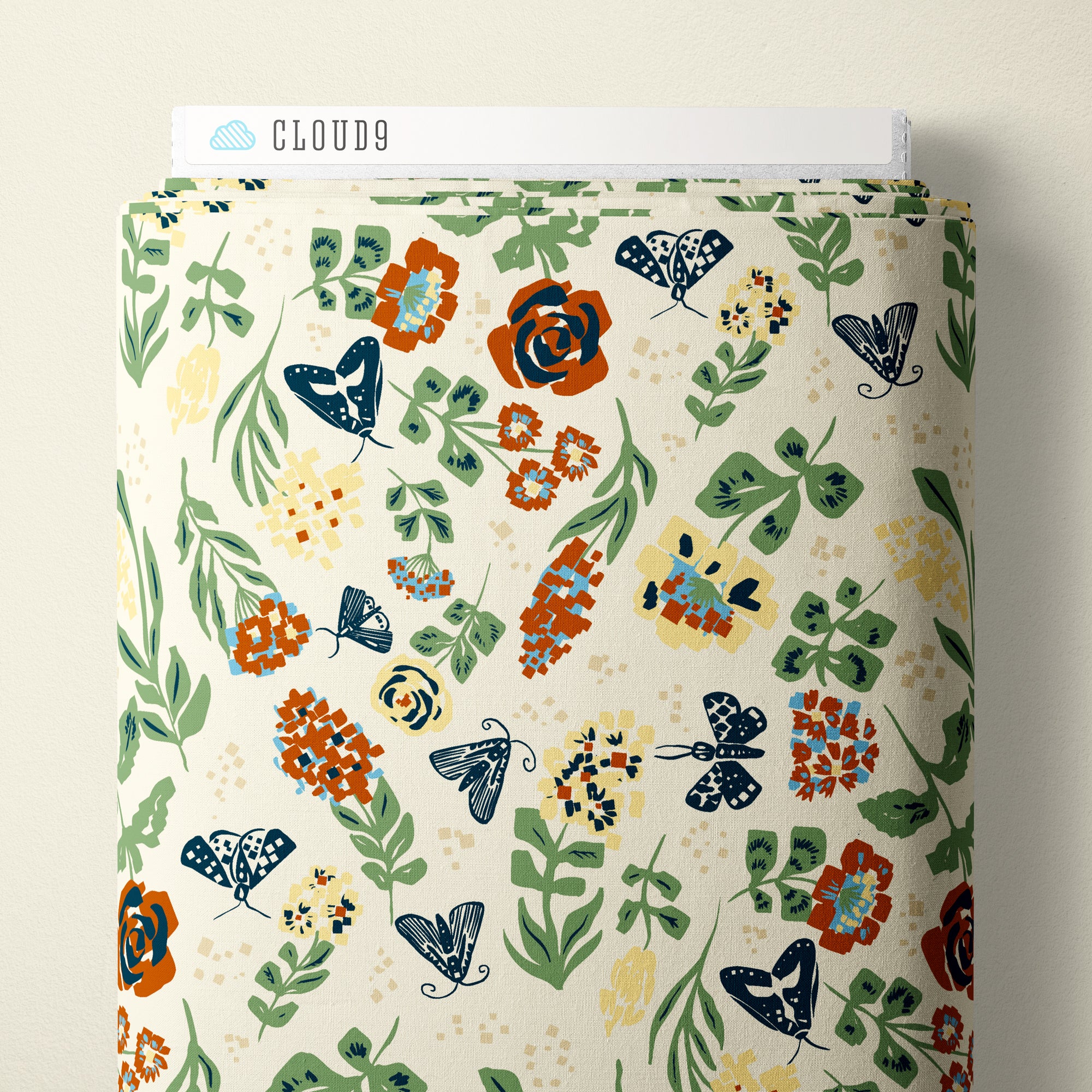 A roll of patterned fabric with a botanical design featuring leaves, flowers, and butterflies on a cream background. A white label at the top reads CLOUD9.