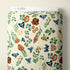 A roll of patterned fabric with a botanical design featuring leaves, flowers, and butterflies on a cream background. A white label at the top reads CLOUD9.