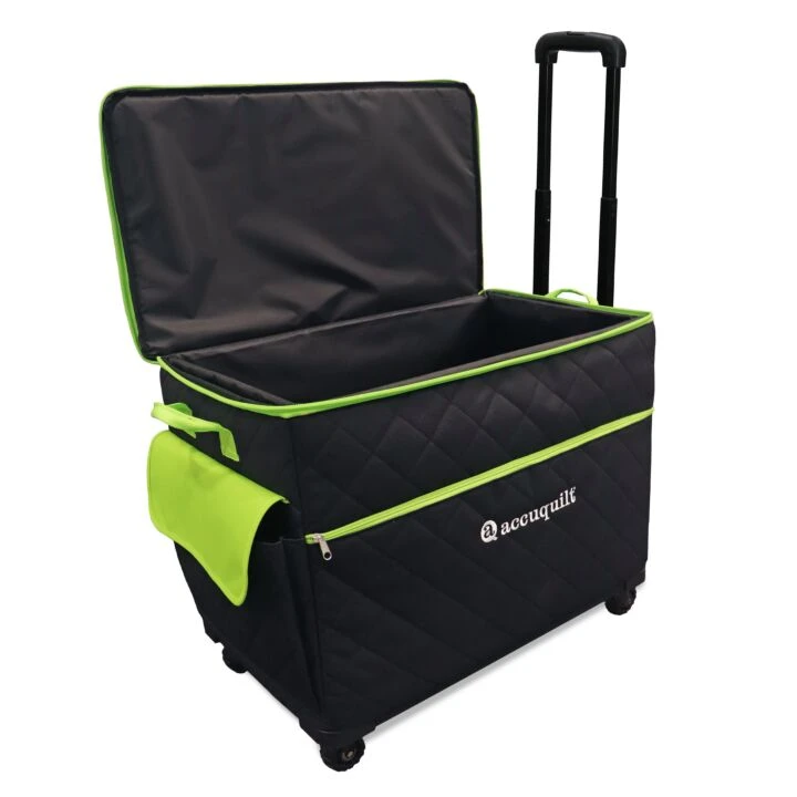 A black quilted rolling bag with bright green trim, an open lid, telescoping handle, and a side pouch, shown on a plain white background. The brand name 'AccuQuilt' is visible on the front.