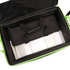 An open black soft case with bright neon green trim, shown from above. Inside, a black padded accessory bag with handles rests on white rectangular items, photographed on a clean white background.