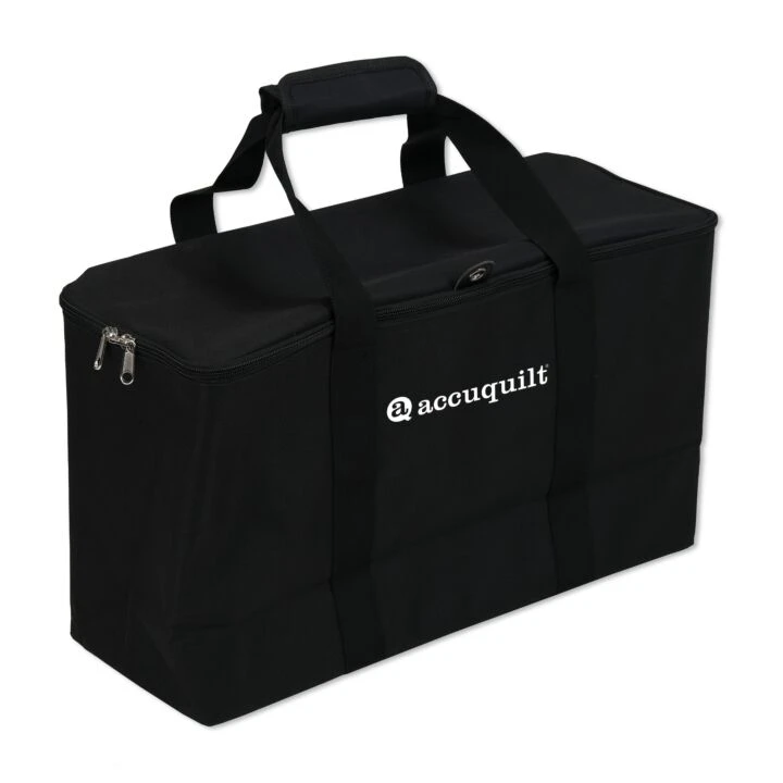 A black fabric storage tote bag with dual top handles, a zippered side pocket, and the white 'accuquilt' logo printed on the front, shown on a plain white background.