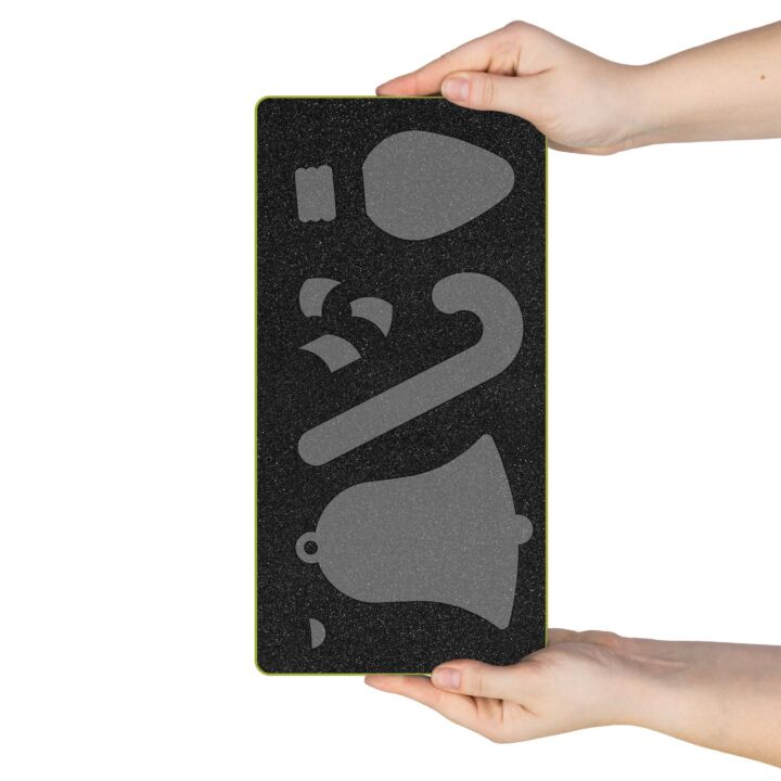 A rectangular black foam practice pad with a gray printed snowboard silhouette, held by two hands against a white background.