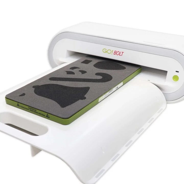 A white GO!BOLT heat press machine with a green and gray heat transfer sheet being pressed, shown on a clean white background.