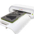 A white GO!BOLT heat press machine with a green and gray heat transfer sheet being pressed, shown on a clean white background.
