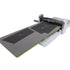 A silver and white paper cutter or die-cutting machine with a long gray cutting mat featuring black rectangular sections, shown on a plain white background.