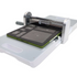 AN AccuQuilt die-cutting machine with a white plastic body, a silver metal roller, and a green and gray cutting mat, shown on a plain white background.