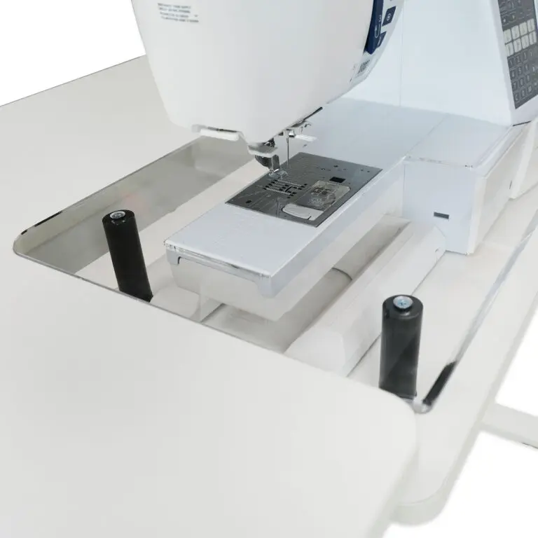 Sewing machine on a white table with a clear acrylic cover