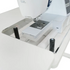 Sewing machine on a white table with a clear acrylic cover