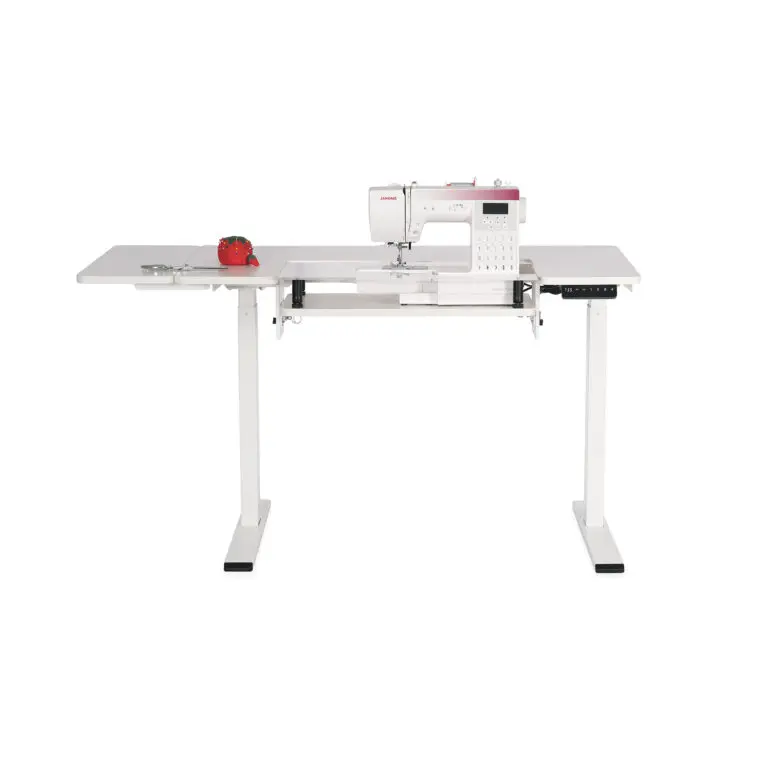White sewing machine on a matching white table with a white background