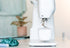 White sewing machine on a light-colored surface with a blurred background