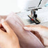 Person using a Bernina sewing machine to sew fabric.