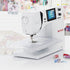 A white Bernina B-475 sewing machine with a digital screen and rotary dials, shown on a white surface with a blurred craft-themed background.