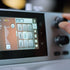 Close-up of a sewing machine with a screen and control knobs.