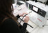 Person using a sewing machine on a table with various items.