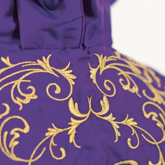 Purple fabric with gold embroidery on a white background