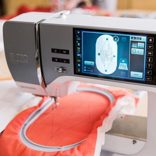 Sewing machine with digital display on a red fabric background