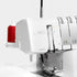 Bernina L460 sewing machine with a spool of red thread on a white background