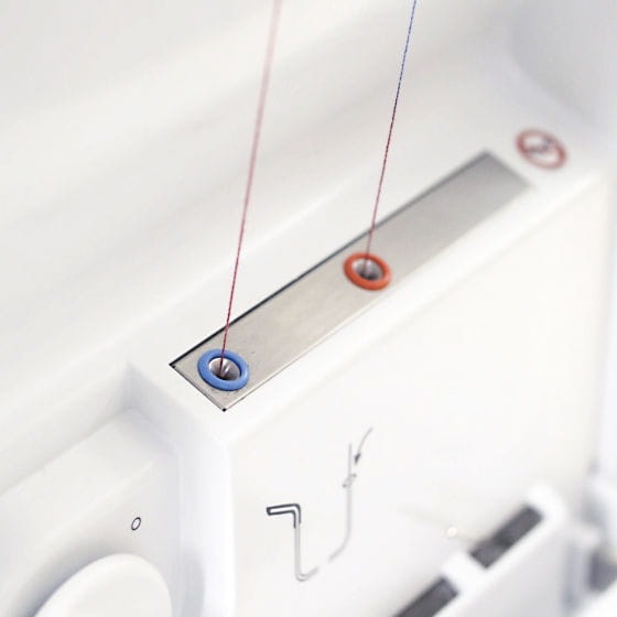 Close-up of a sewing machine needle and thread on a white background