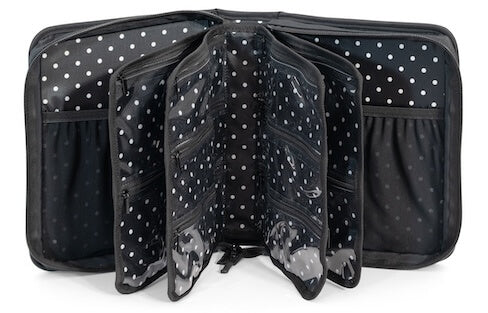 An open black organizer bag with white polka dots, showing multiple interior pockets, zipper compartments, and clear plastic ID windows, photographed on a white background.