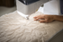 Sewing machine quilting a piece of fabric with a hand guiding it.
