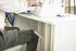 Person using a computer at a desk with a focus on the legs and feet.