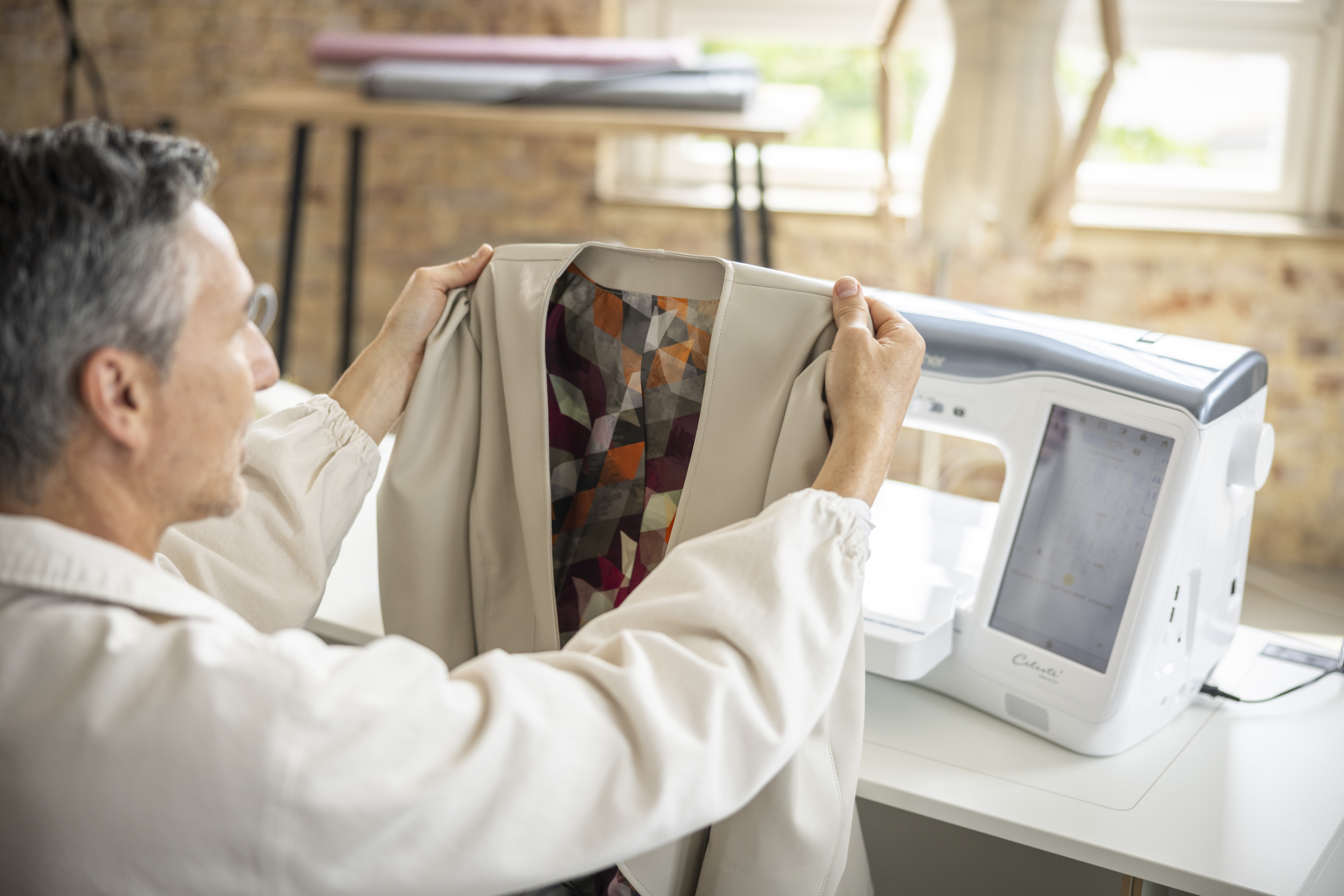 Person using a sewing machine to work on a piece of fabric.