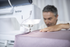 Person using a Brother sewing machine on a white background
