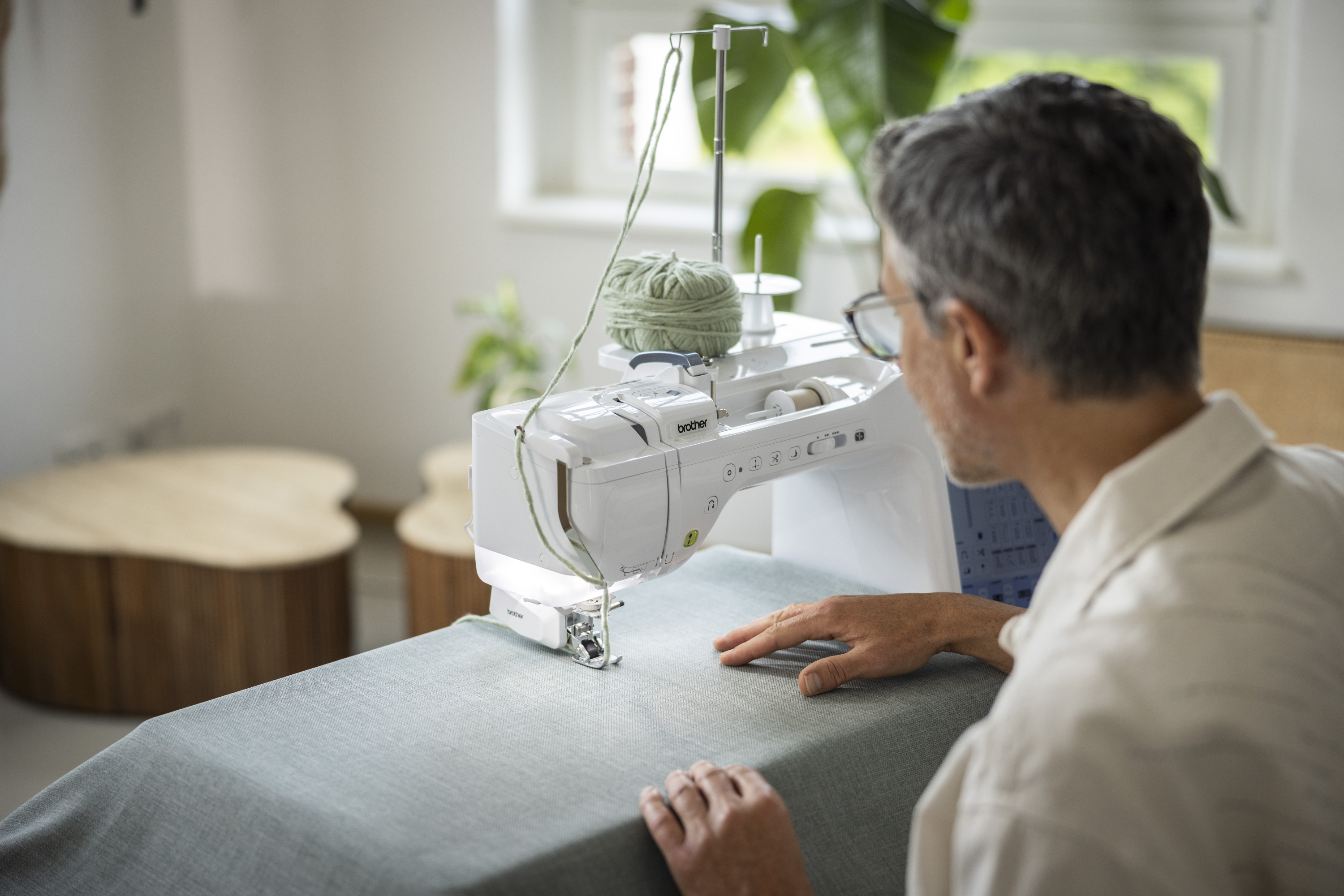 Person using a sewing machine in a home setting