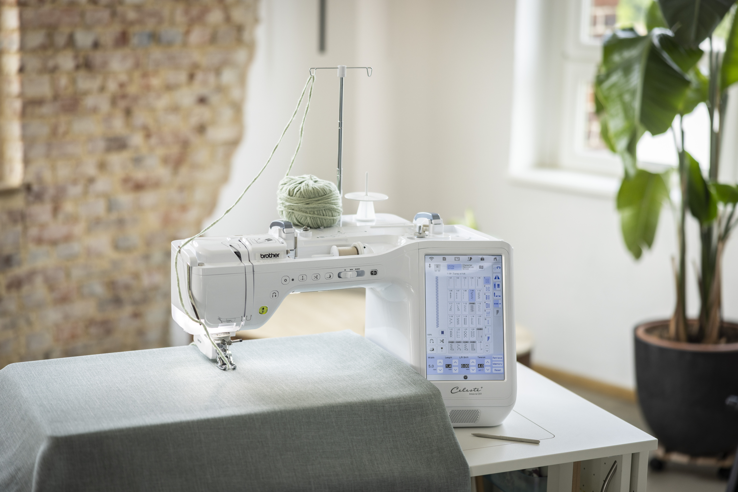 Sewing machine on a table with a plant in the background