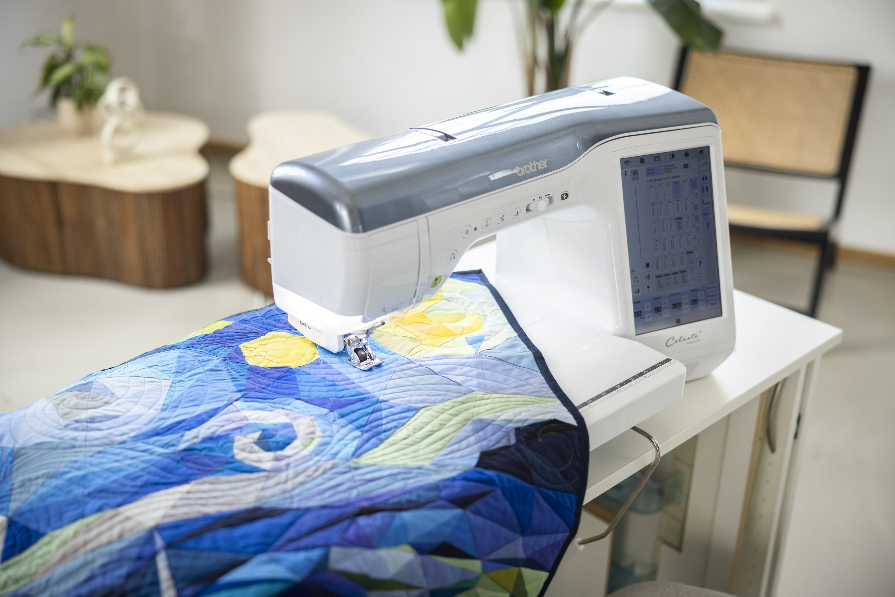 Sewing machine with a quilt on a table in a room setting