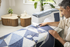 Man working on a quilt with a sewing machine in a home setting