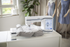 Embroidery machine on a table with mannequins and a dress in the background