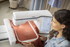 Woman using a Brother embroidery machine on a piece of fabric.