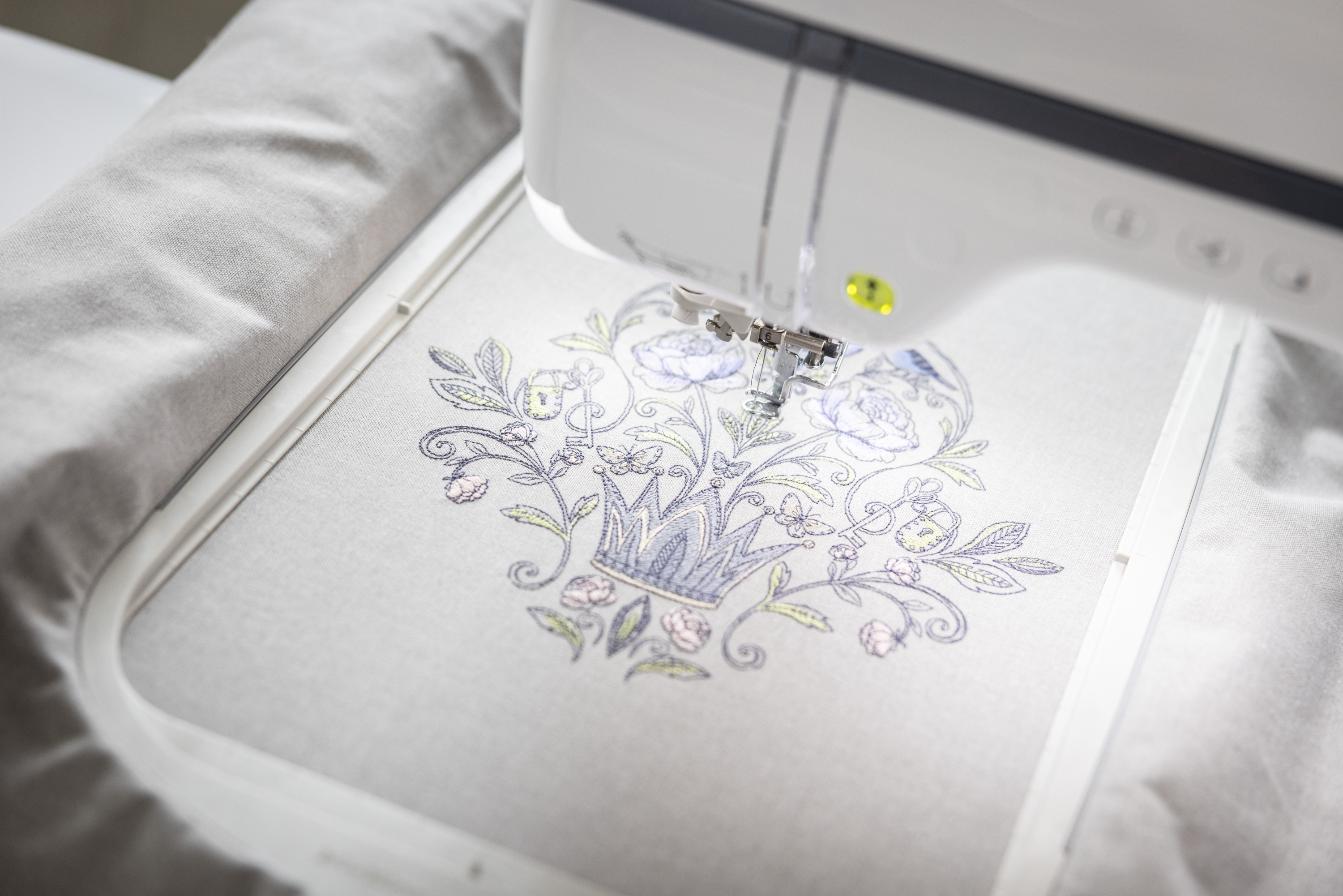 Embroidery machine with floral design on a white fabric