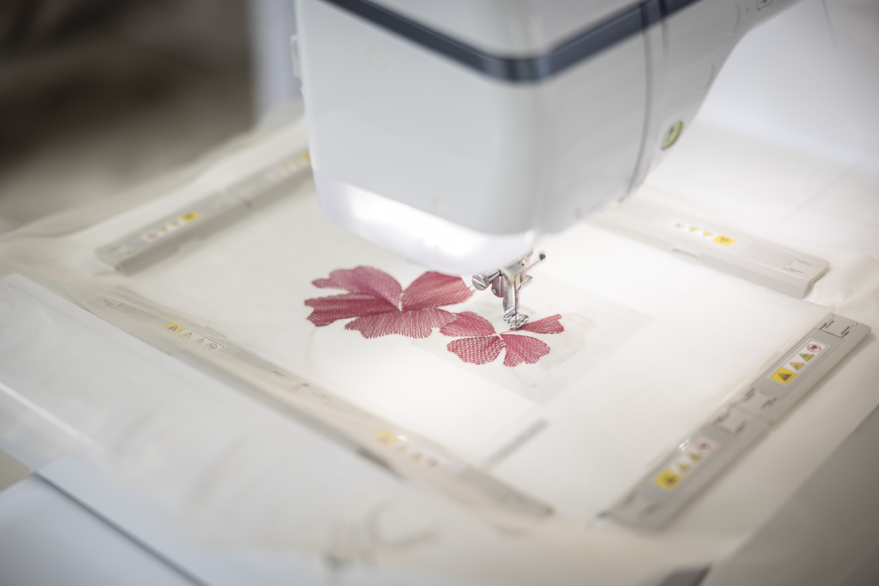 Embroidery machine with a floral design on a white background