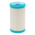Spool of Coats Cotton Covered thread with blue label on a white background
