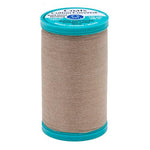 Spool of Coats Cotton Covered thread with teal cap on a white background