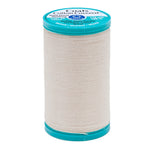 Spool of Coats cotton-covered thread with teal lid on a white background