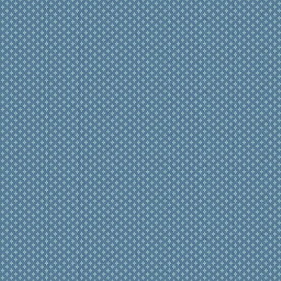 A close-up of a repeating fabric in muted medium blue with small white geometric motifs arranged in a grid.