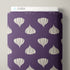 A roll of purple fabric featuring a repeating pattern of stylized garlic bulbs in off-white, shown standing upright with a white Cloud9 label visible at the top against a light gray background.