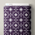 A roll of patterned fabric with a dark purple and white geometric floral design, shown standing upright with a white label that reads CLOUD9 at the top.