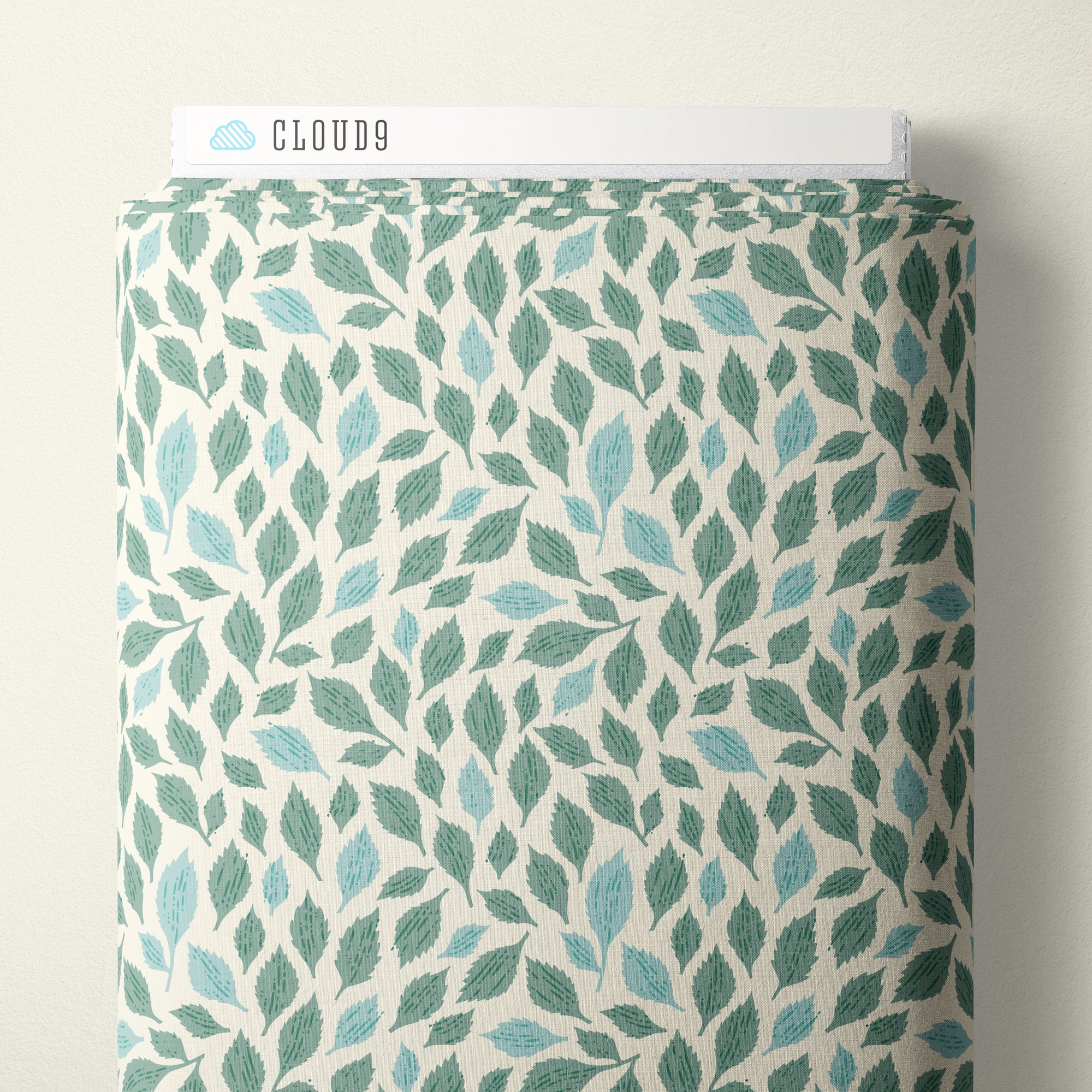 A roll of patterned fabric with a repeating leaf design in teal, mint, and light blue on an off-white background. A white label at the top reads CLOUD9.