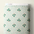 A roll of patterned fabric with a white background, light blue polka dots, and green pine branch motifs, shown with a white Cloud9 paperboard label at the top.