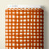 A roll of fabric or paper with an orange and white hand-drawn checkered pattern, shown with a white header card labeled CLOUD9 on a light beige background.