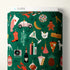 Fabric bolt with a colorful pattern of various items on a green background
