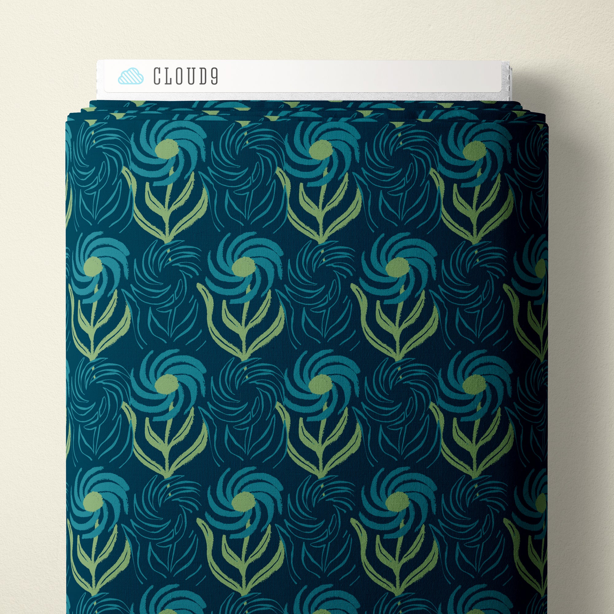 A roll of patterned fabric with a repeating floral swirl design in teal, blue, and light green on a dark navy background, shown against a plain light beige wall. A white header card at the top reads CLOUD9.
