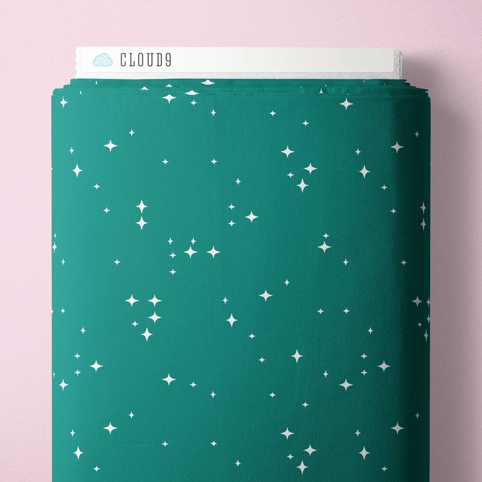 Green fabric bolt with star pattern on a pink background
