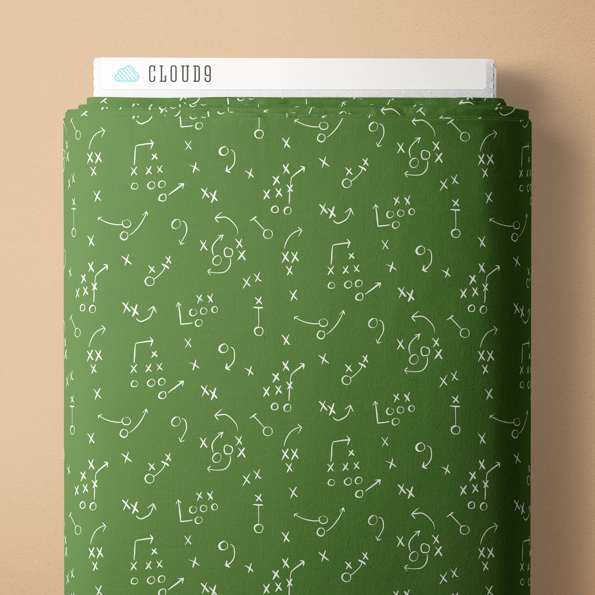 Green fabric with white football play patterns on a beige background