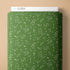 Green fabric with white football play patterns on a beige background