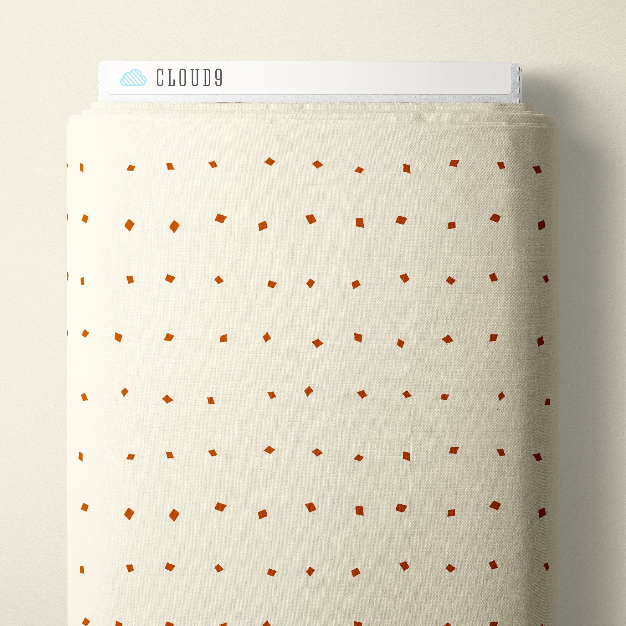 A roll of cream-colored fabric with a small, evenly spaced pattern of rust-brown diamond and square motifs, shown against a neutral beige background. A white header card at the top displays the brand name 'CLOUD9'.